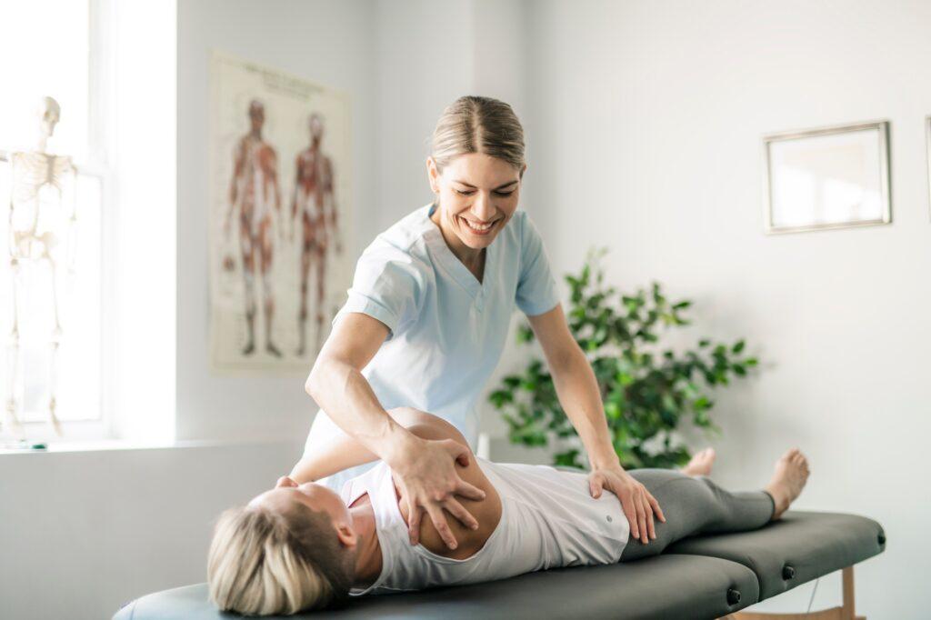 Physiotherapeutin behandelt Patient auf Liege | Therapieliegen